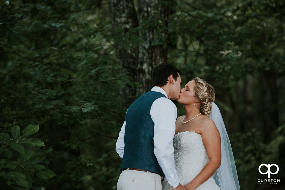 Groom and bride kissing during their first look.