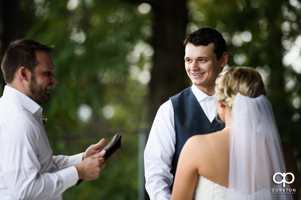 Groom smiling during the ceremony.