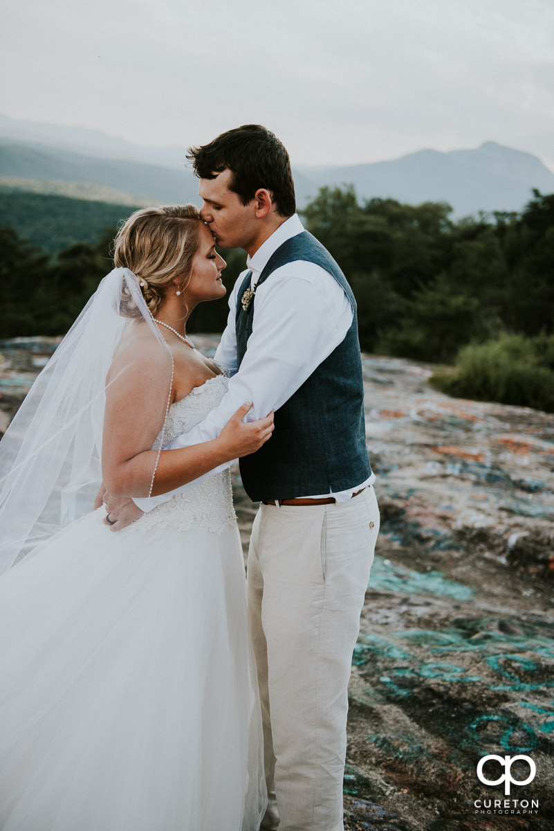 Bride and groom hugging on Bald Rock in the mountains of South Carolina.