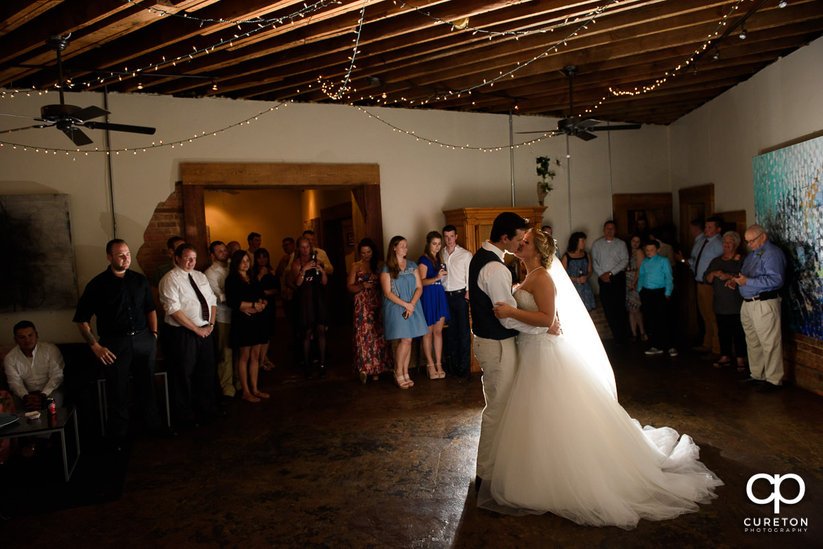 Bride and groom having a first dance at Artisan Traders during their wedding reception.
