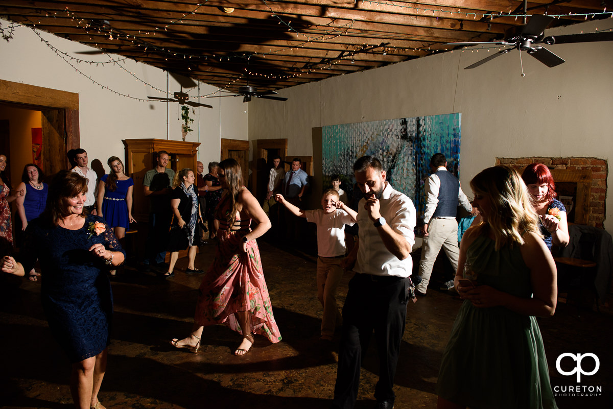 Wedding reception guests dancing at Artisan Traders.