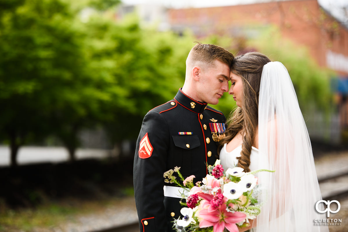 Bride and groom standing in front of railroad tracks in downtown Greenville,SC.