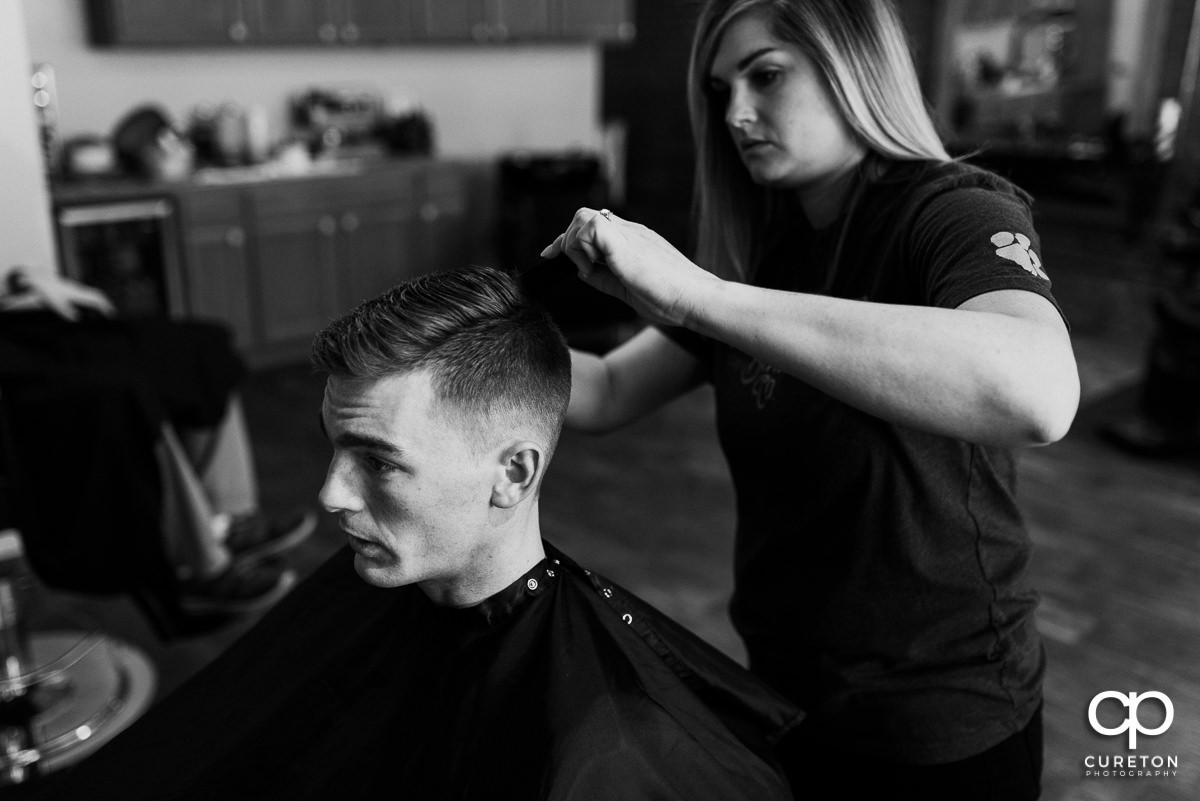Groom getting his hair trimmer at The West End Barber shop on his wedding day.