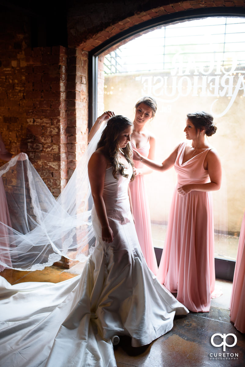 Bridesmaids helping with the veil.