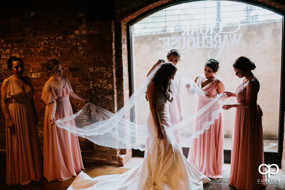 Bridesmaids helping put on her veil The Old Cigar Warehouse in downtown Greenville,SC.