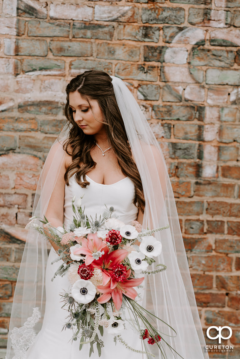 Gorgeous bride holding her bouquet from Dahlia outside The Old Cigar Warehouse in Greenville