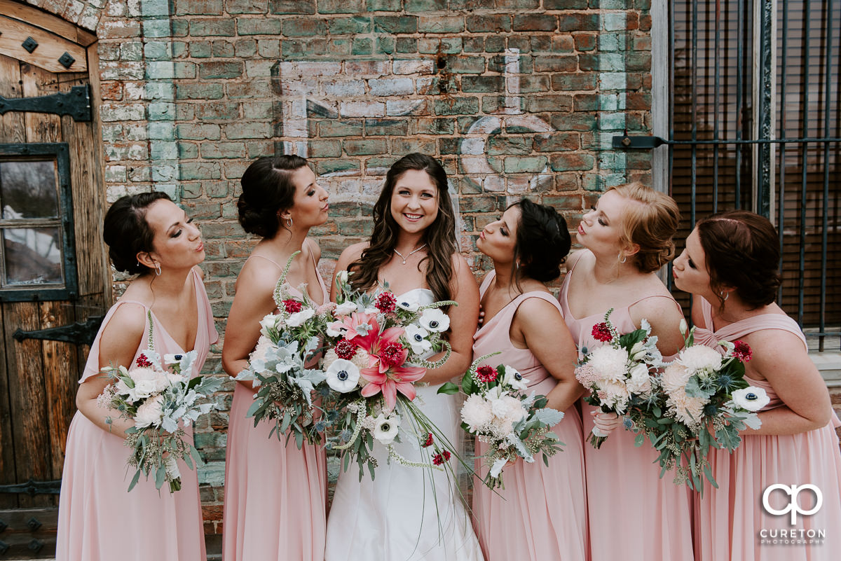 Bridesmaids all looking at the bride at The Old Cigar Warehouse in Greenville.