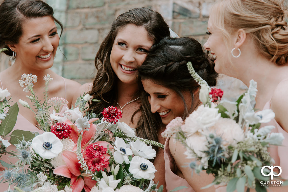 Bride and bridesmaids laughing.