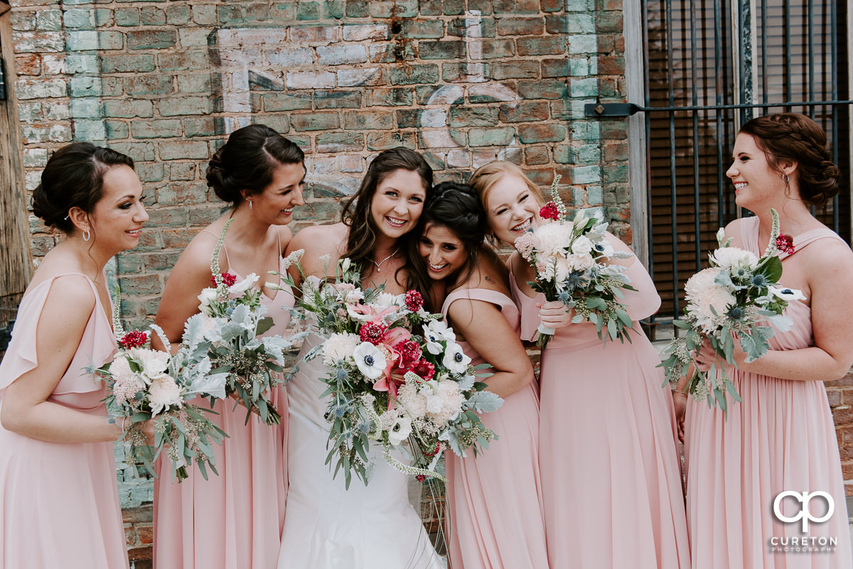 Bride and bridesmaids laughing before the ceremony.