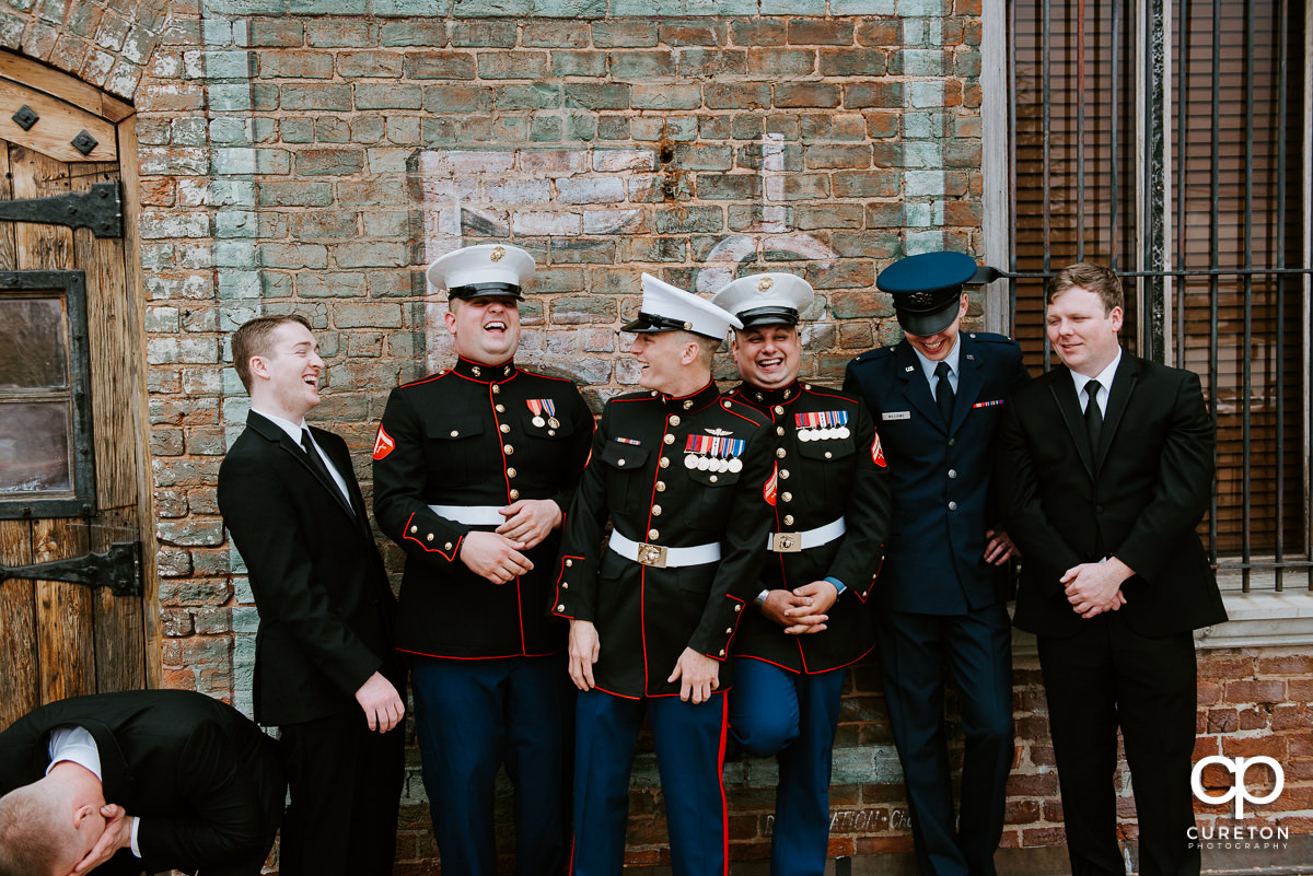 Groomsmen in uniform laughing.