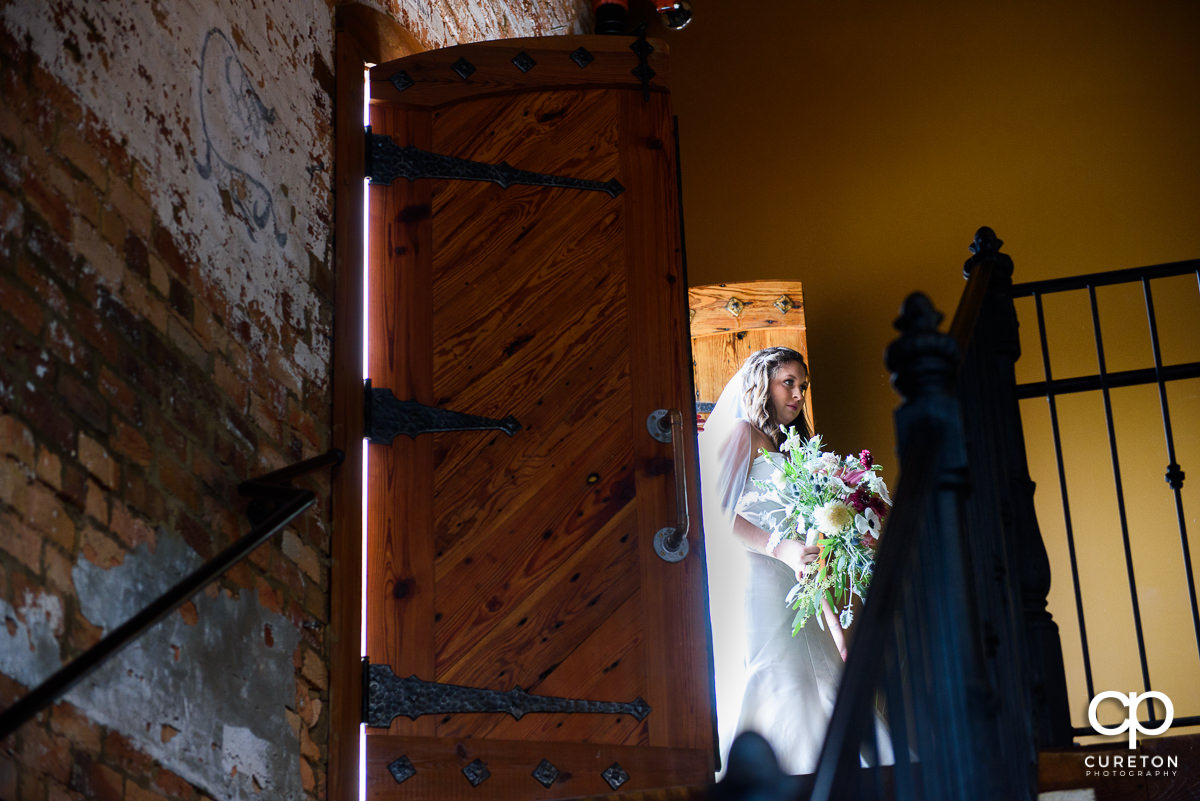 Bride coming in the door at the top of the steps at The Old Cigar Warehouse wedding ceremony.