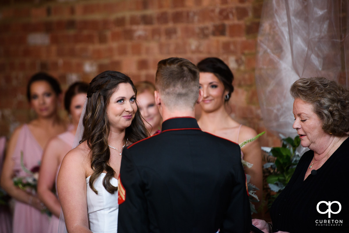 Bride smiling at her groom during the wedding ceremony.