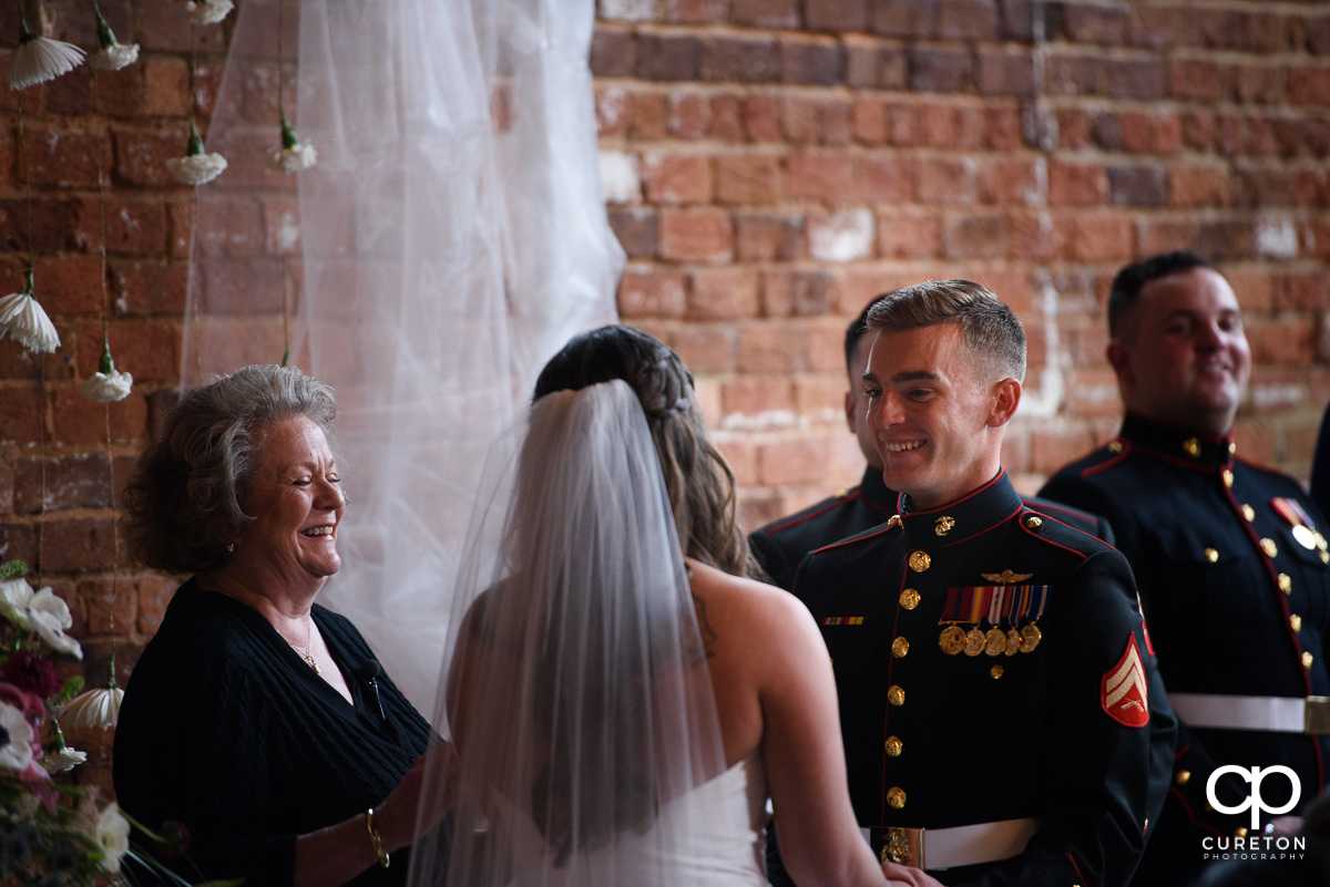 Groom smiling at his bride during the wedding ceremony.