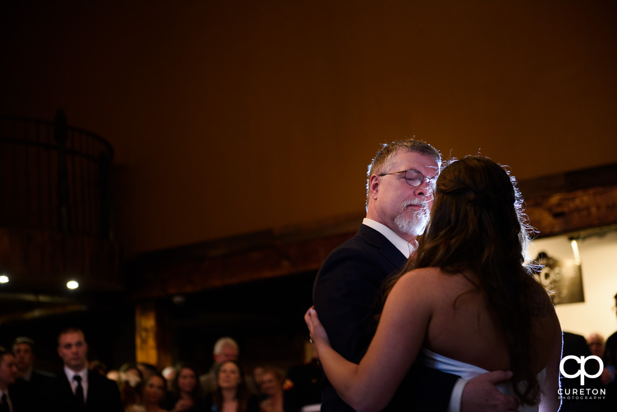 Father of the bride dancing with his daughter at the reception.