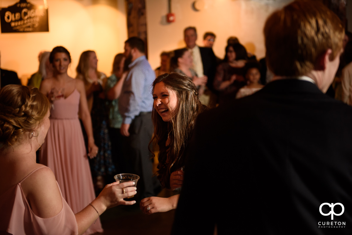 Wedding guests smiling and dancing at The Old Cigar Warehouse.