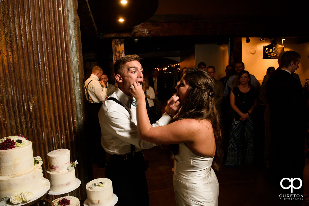 Bride and groom feeding cake to each other.