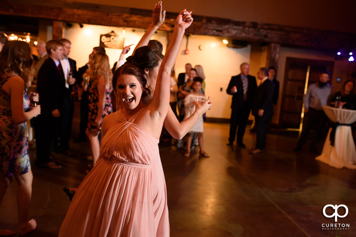 Wedding guests smiling and dancing at The Old Cigar Warehouse.