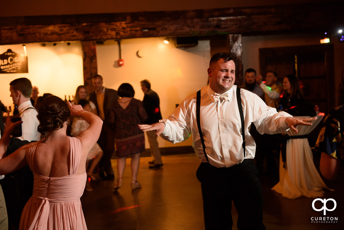Wedding guests smiling and dancing at The Old Cigar Warehouse.