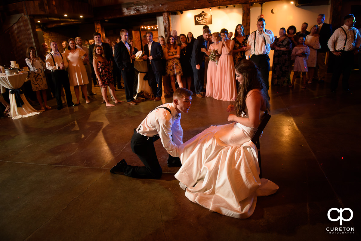 Groom removing the garter.