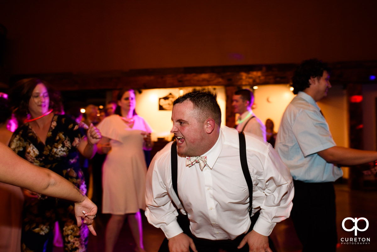 Wedding guests smiling and dancing at The Old Cigar Warehouse.