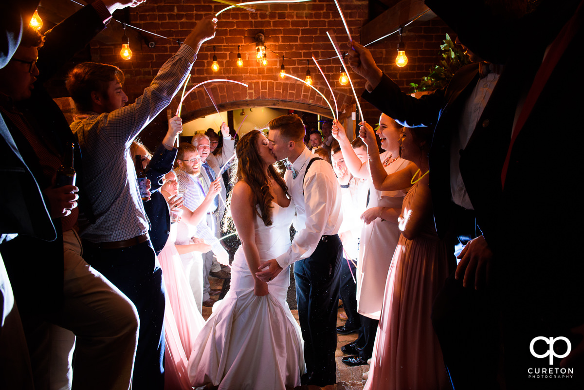 Bride and groom making an epic glow stick exit at The Old Cigar Warehouse wedding reception.