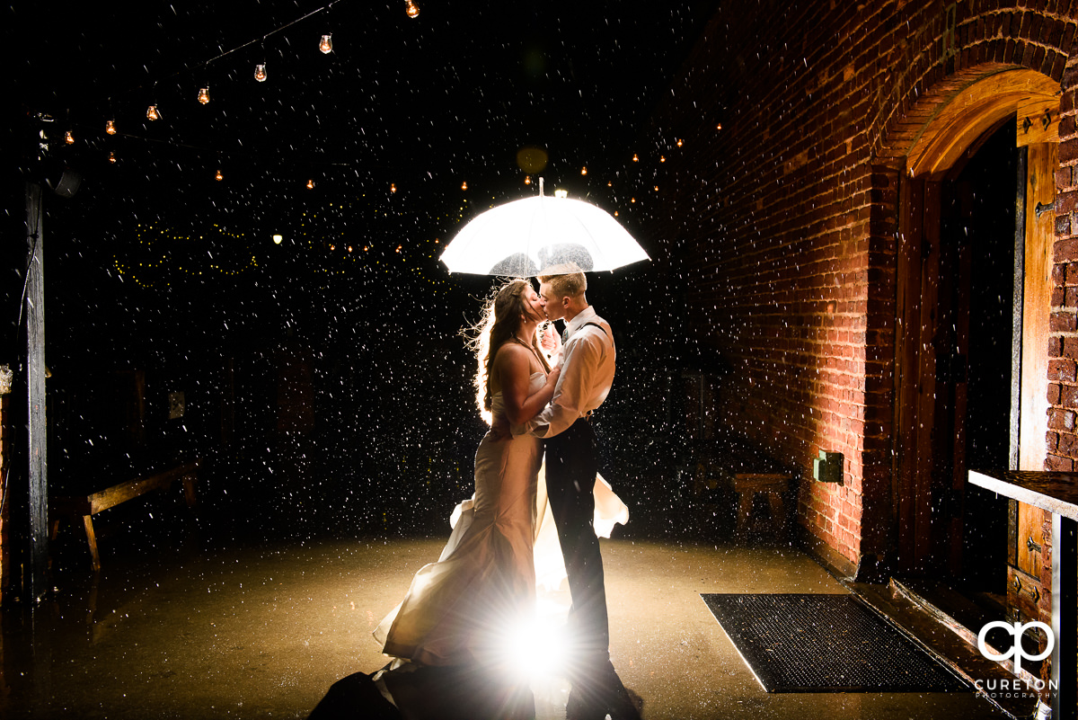 Bride and groom dancing in the rain at their Old Cigar Warehouse rainy day wedding reception.