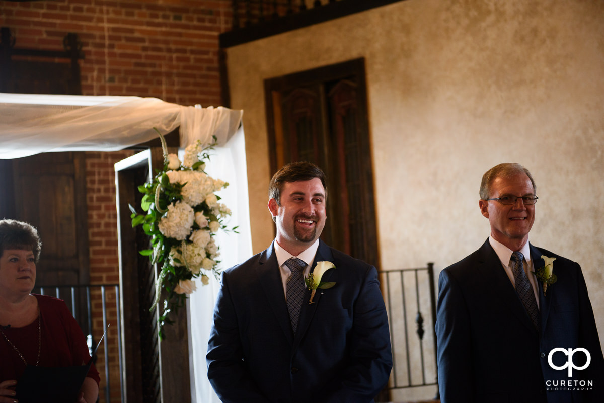 Groom smiling as he sees his bride for the first time.