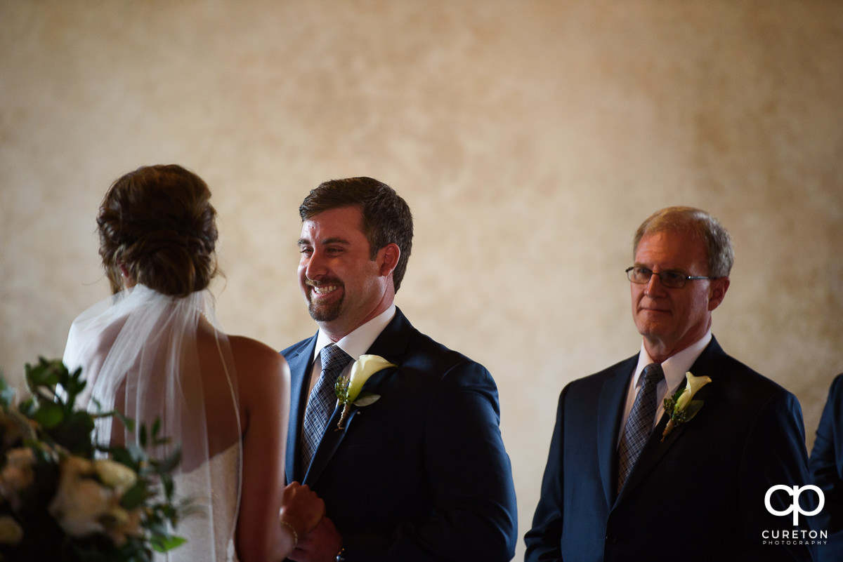 Groom smiling during the ceremony.