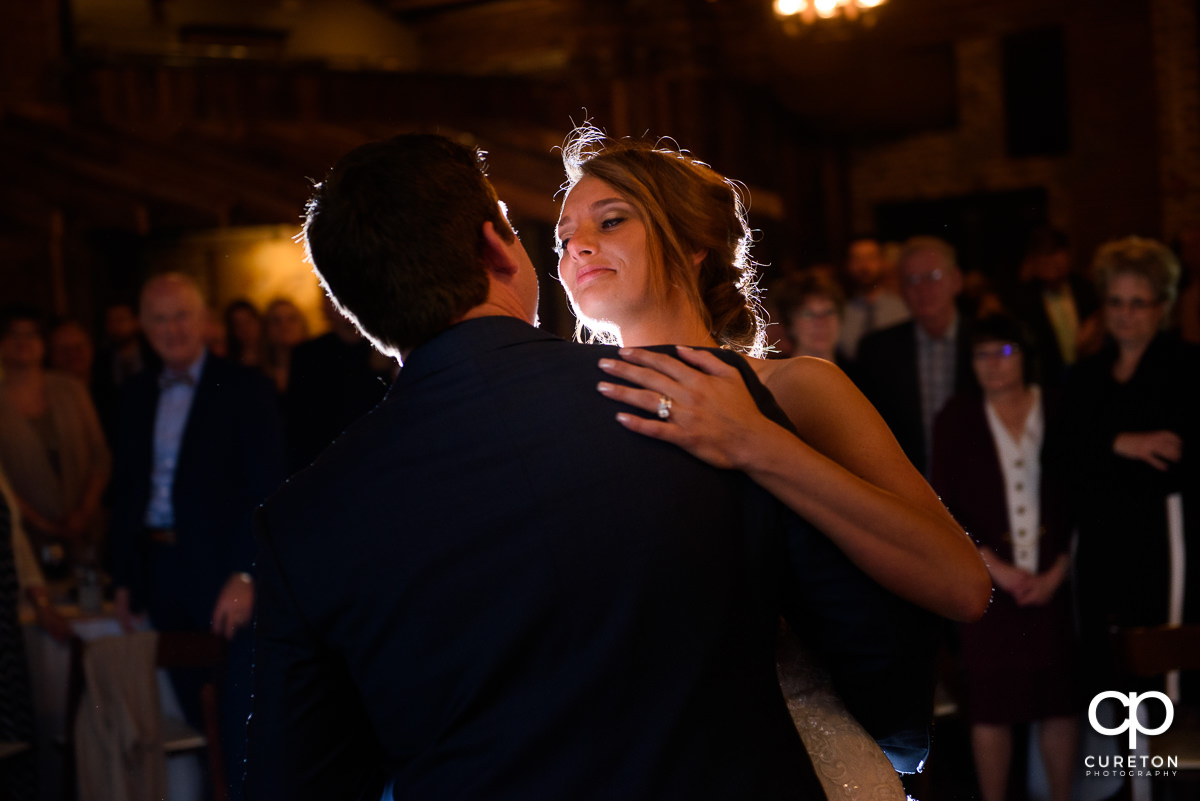 Bride smiling at her husband during their first dance.