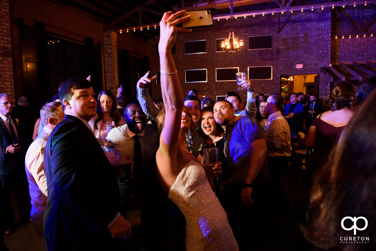 Bride taking a selfie with her wedding guests during the reception.