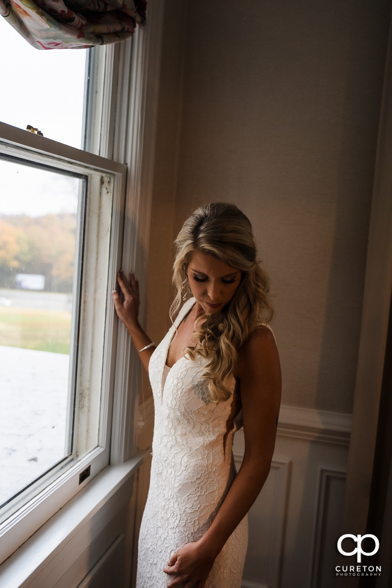 Bride standing in front of a window.