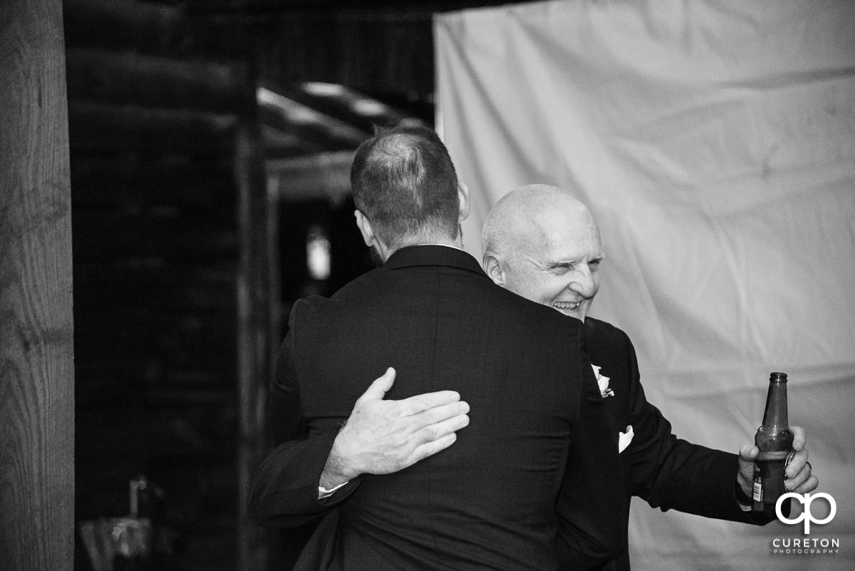 Father of the bride hugging the groom.