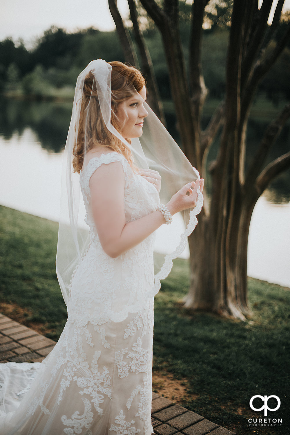 Bride looking out at the lake at Furman during her bridal session.