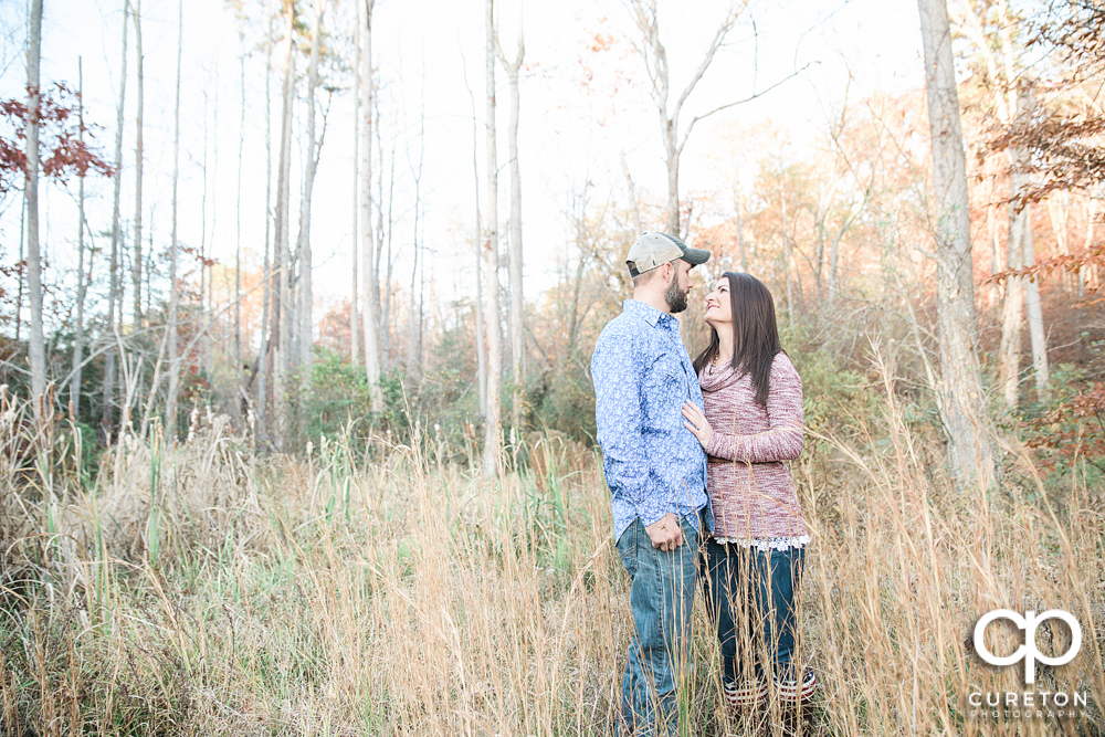 Future bride and groom standing in a field.