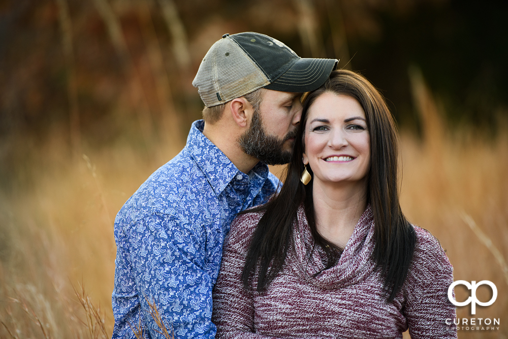 Engaged couple standing in tall grass during their engagement session in Blue Ridge.