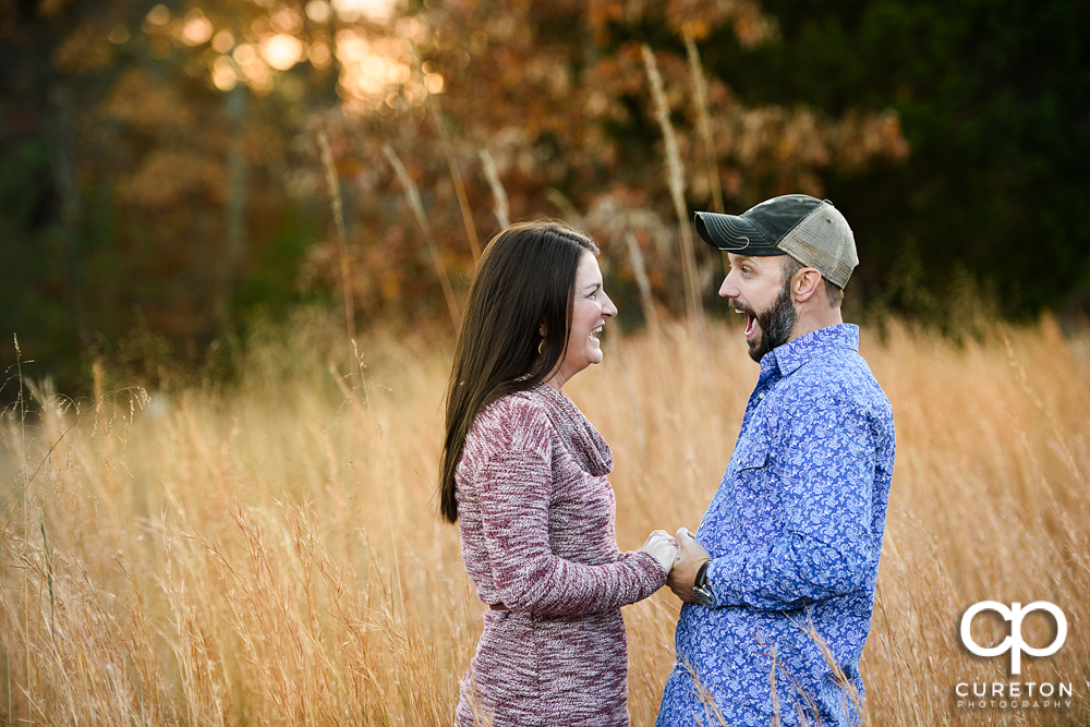 Engaged couple laughing.