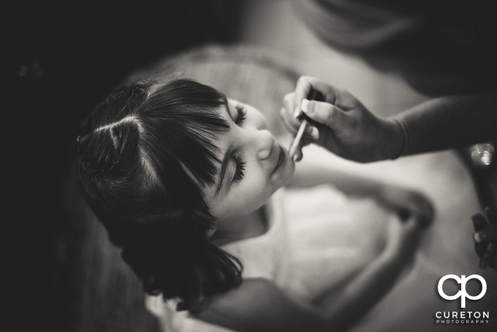 Flower girl getting make up applied.