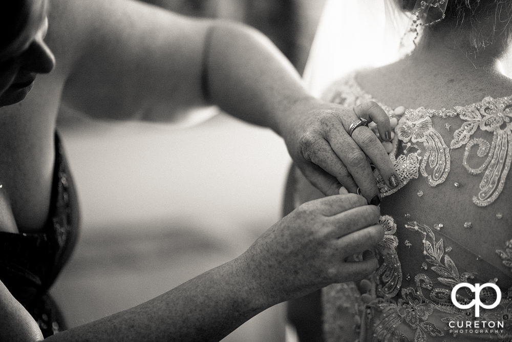 The bride being helped into her dress.