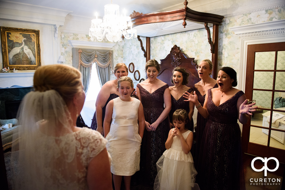 The bride being revealed to the bridesmaids for the first time.