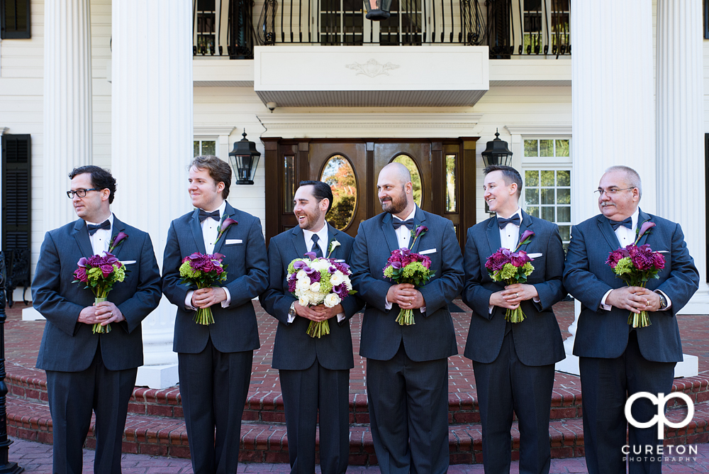 The groomsmen holding the bridesmaids' flowers