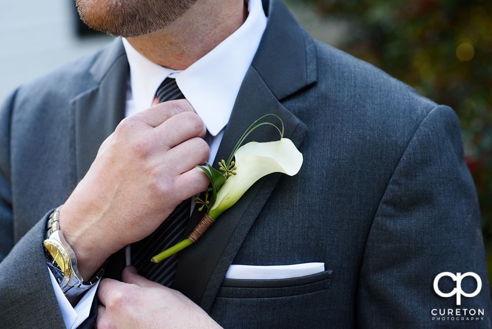 Groom fixing his tie.