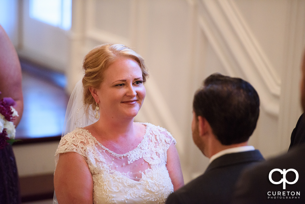 Bride smiling at the groom during the ceremony.