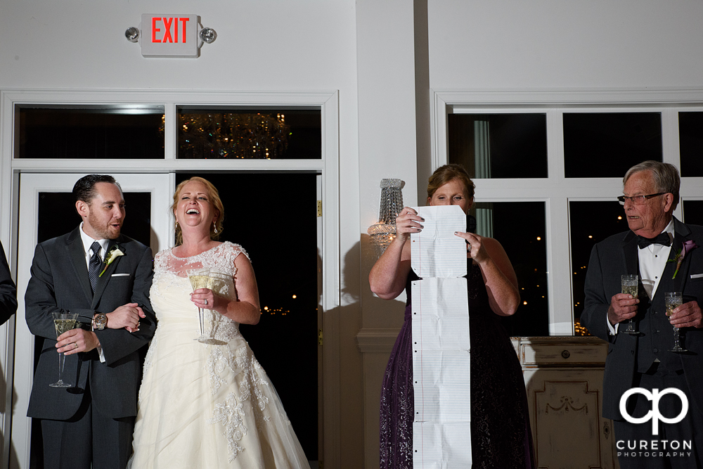 The bride and groom listen as the maid of honor and best man give a toast