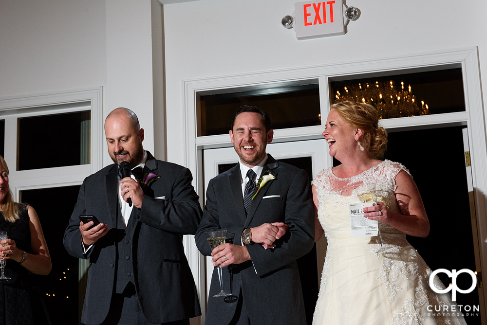 The bride and groom listen as the maid of honor and best man give a toast