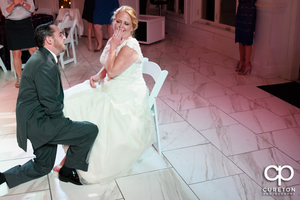 Groom taking off the garter.