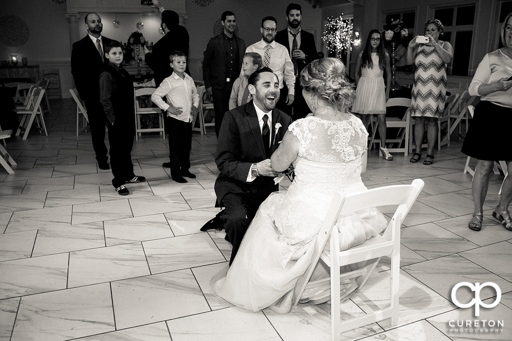 Groom taking off the garter.