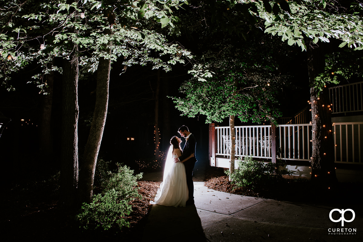Bride and groom backlit in the garden at night after their Ryan Nicholas Inn wedding.