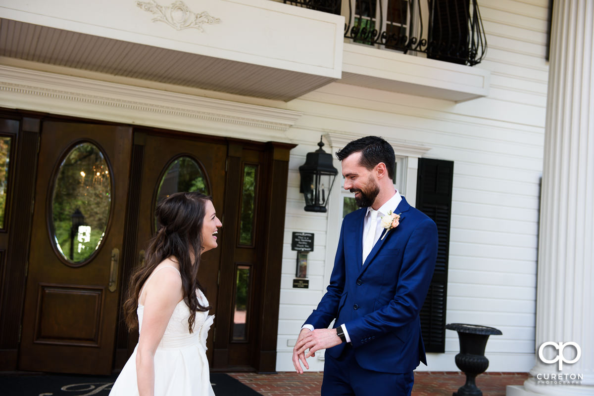 Bride and groom sharing a first look on the porch of the Ryan Nicholas Inn before their wedding.