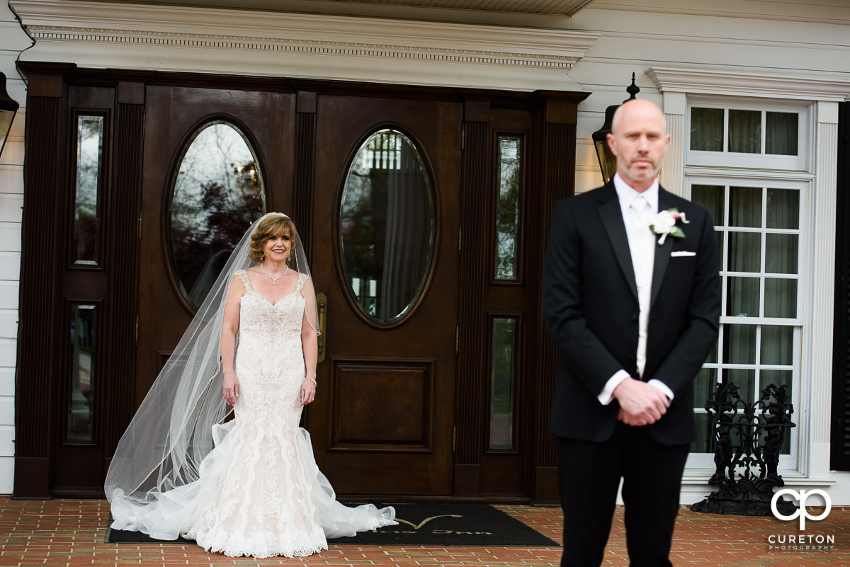 Bride walking out of the front of Ryan Nicholas Inn for a first look with her groom.