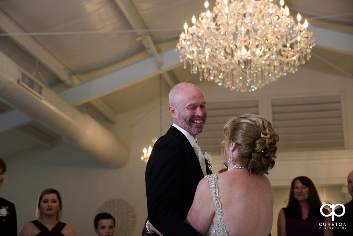 Groom smiling at the first dance during the Ryan Nicholas Inn wedding reception.